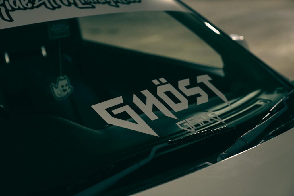 Detailed shot of a car windshield featuring a bold Ghost sticker.