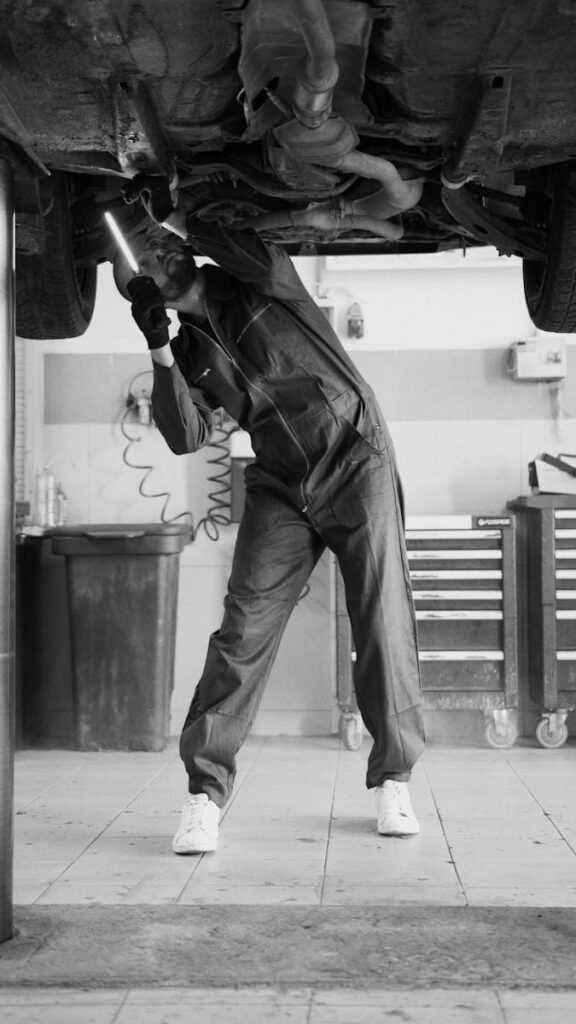 Undercarriage Car Wash: The Ultimate Guide to Protecting Your Vehicle 2 A mechanic inspecting a vehicle in a workshop, highlighting automotive maintenance.