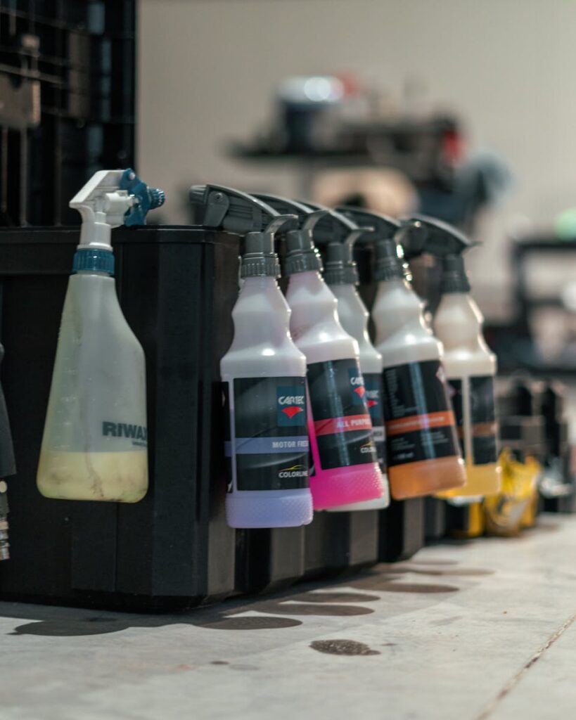 The Best Car Washing Kit Options for At-Home Use vs. Professional Service at Fusion 1 Close-up of various car care spray bottles lined up in a workshop.