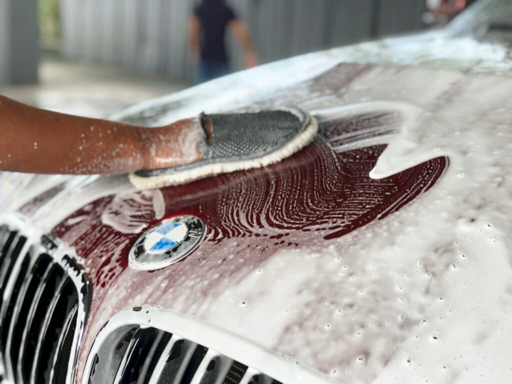 Hand Car Wash vs. Machine Wash: What’s Best for Your Car in Frederick 3 a person washing a car with a sponge