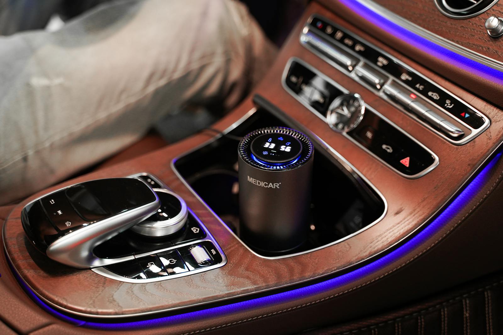 Close-up of a luxury car's center console featuring an air purifier and elegant wooden detailing.