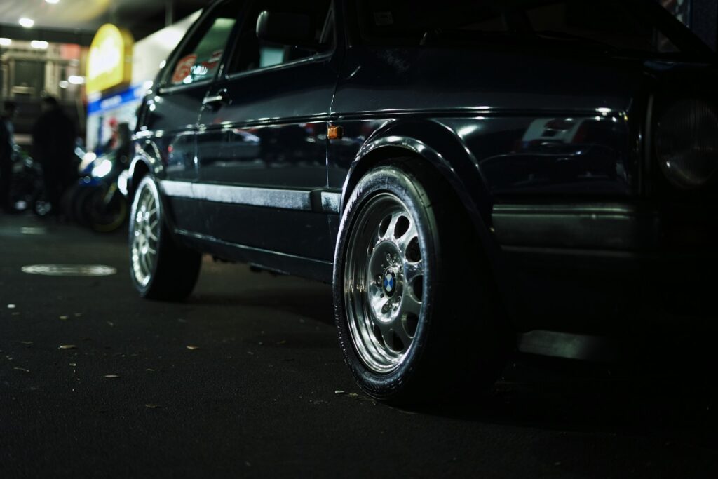 A dark car with polished wheels.