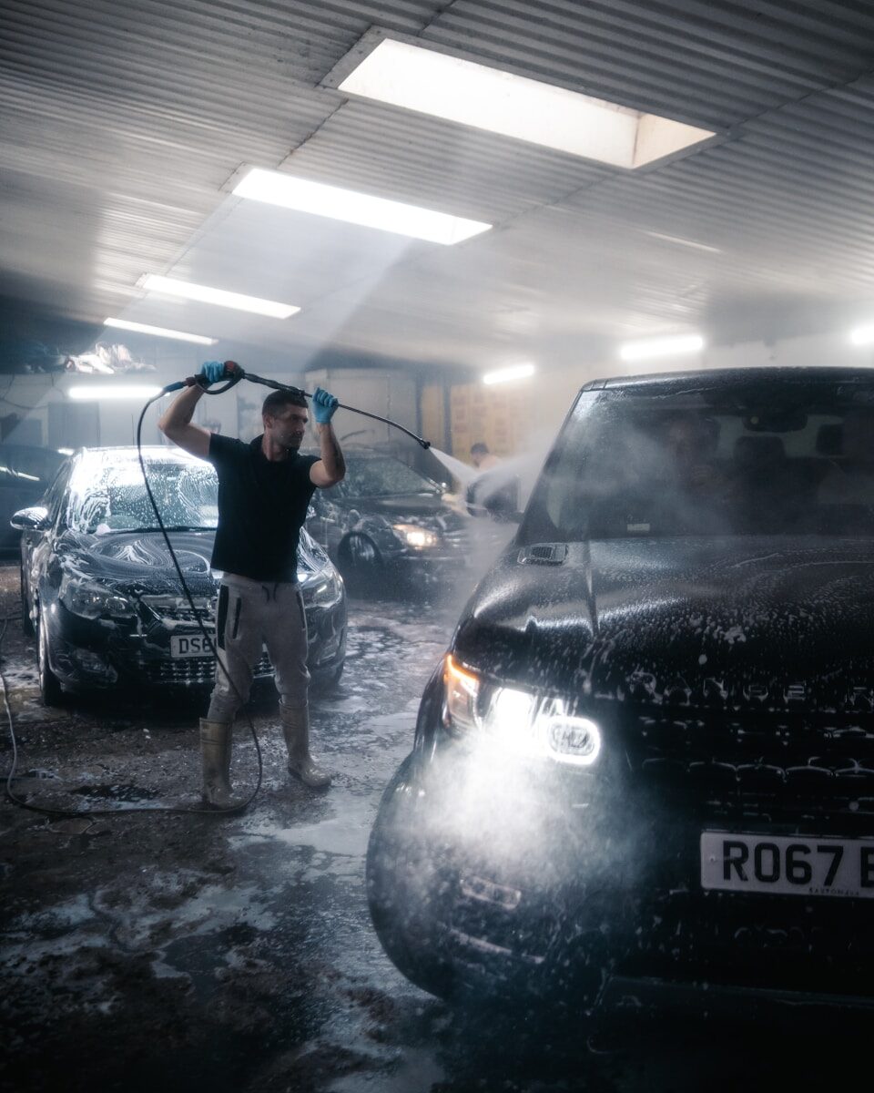 Photo by Chuko Cribb a person standing next to a car