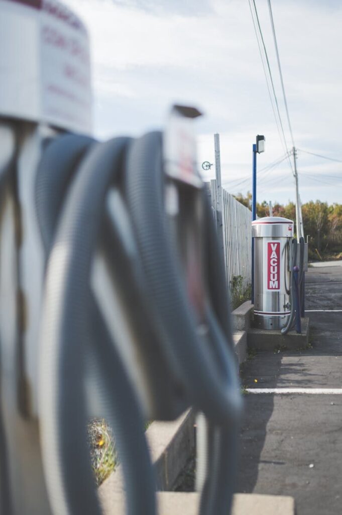 Vertical shot of an industrial vacuum station with stainless steel and hoses outdoors.