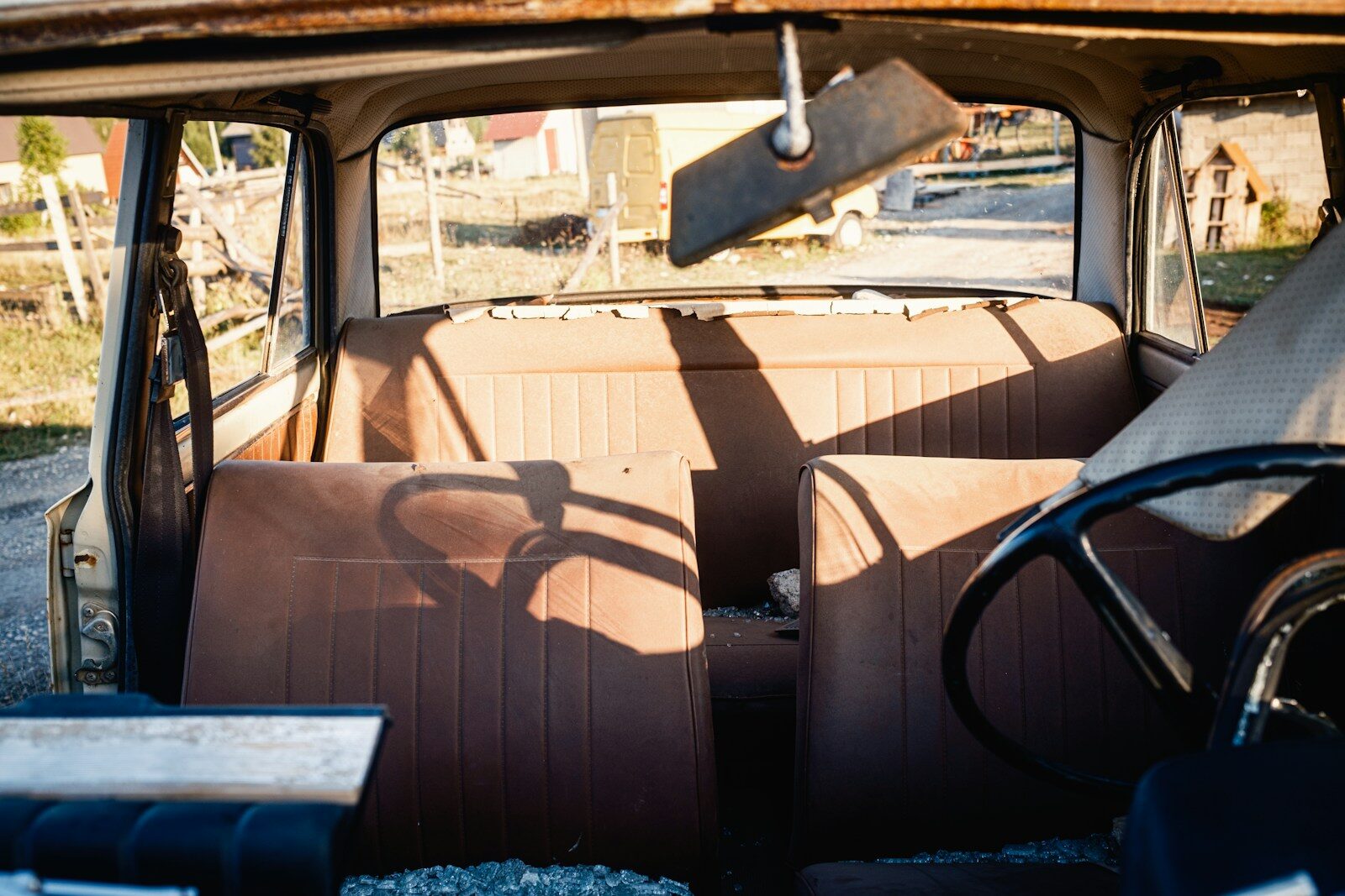 Interior of an old, abandoned car with rusty seats.