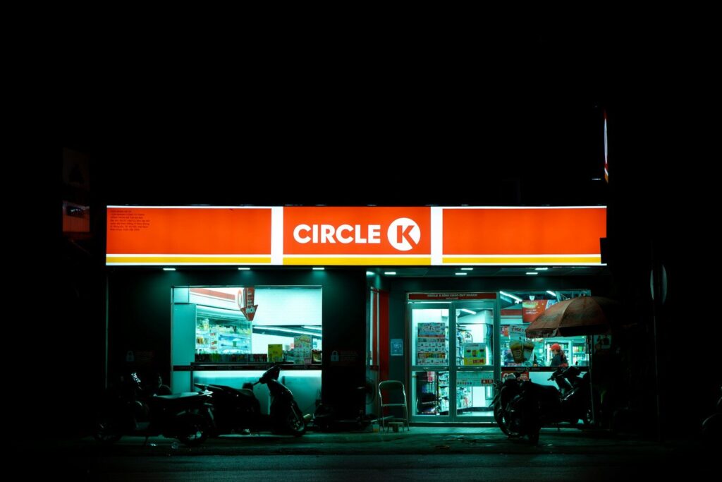 A store front at night with a motorcycle parked in front of it