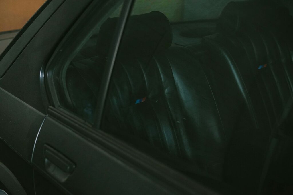 Dark leather car seats seen through window