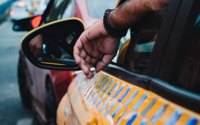 a man is holding his hand out of a car window