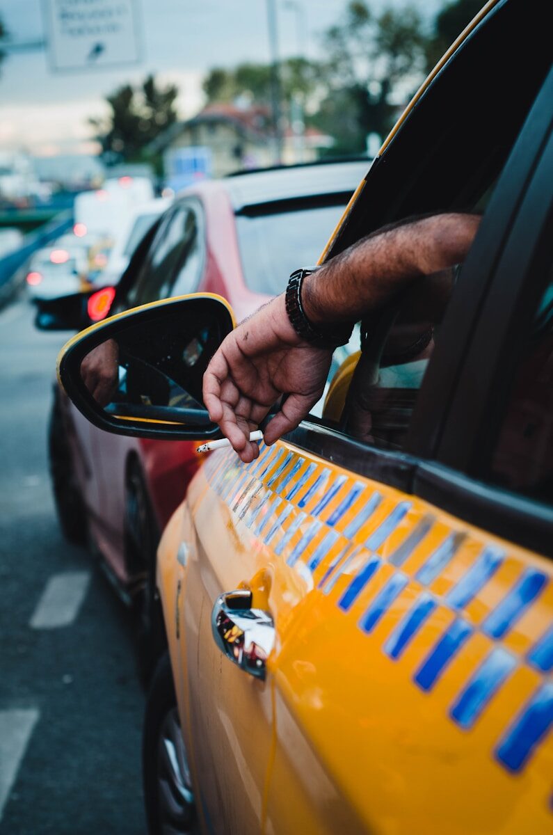 Photo by Ajdin Coric a man is holding his hand out of a car window
