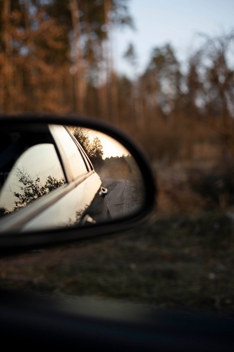 a side view mirror showing a person in a car